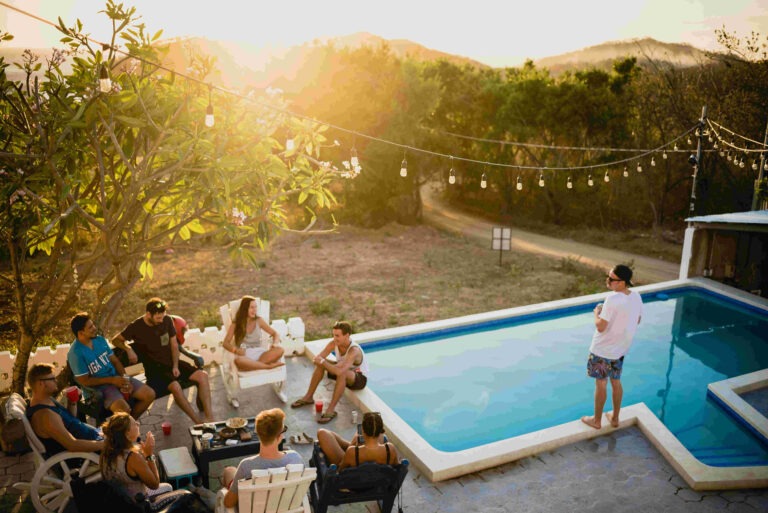 A group of people next to a pool at dawn in a backyard. This setting may be one of the best places to celebrate a birthday in Charlotte NC. Your own backyard may become a serene and inviting setting, perfect for intimate birthday gatherings and celebrations.