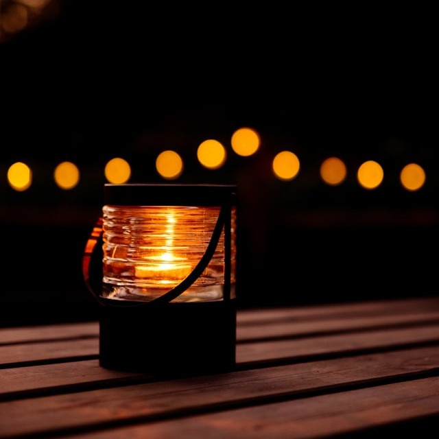 Candle in glass jar symbolizing the ambiance for birthday venues in Charlotte NC, on a dinner cruise on Lake Norman.